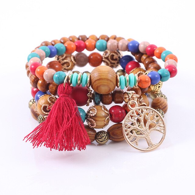 Stack of multi-strand bohemian bracelets featuring colorful wood and turquoise beads a vibrant red tassel and a prominent gold Tree of Life charm