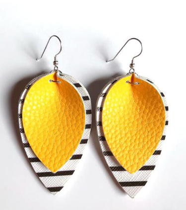 Faux leather dangle earrings featuring layered teardrop shapes with a bright yellow textured top layer and a bottom layer of white with thin horizontal black stripes on silver ear hooks against a white background
