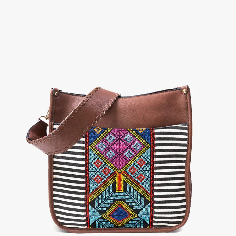Brown faux leather shoulder bag with black and white horizontal stripes on the body and a central panel featuring colorful geometric embroidery in shades of pink blue yellow and red, complete with a decorative stitched strap